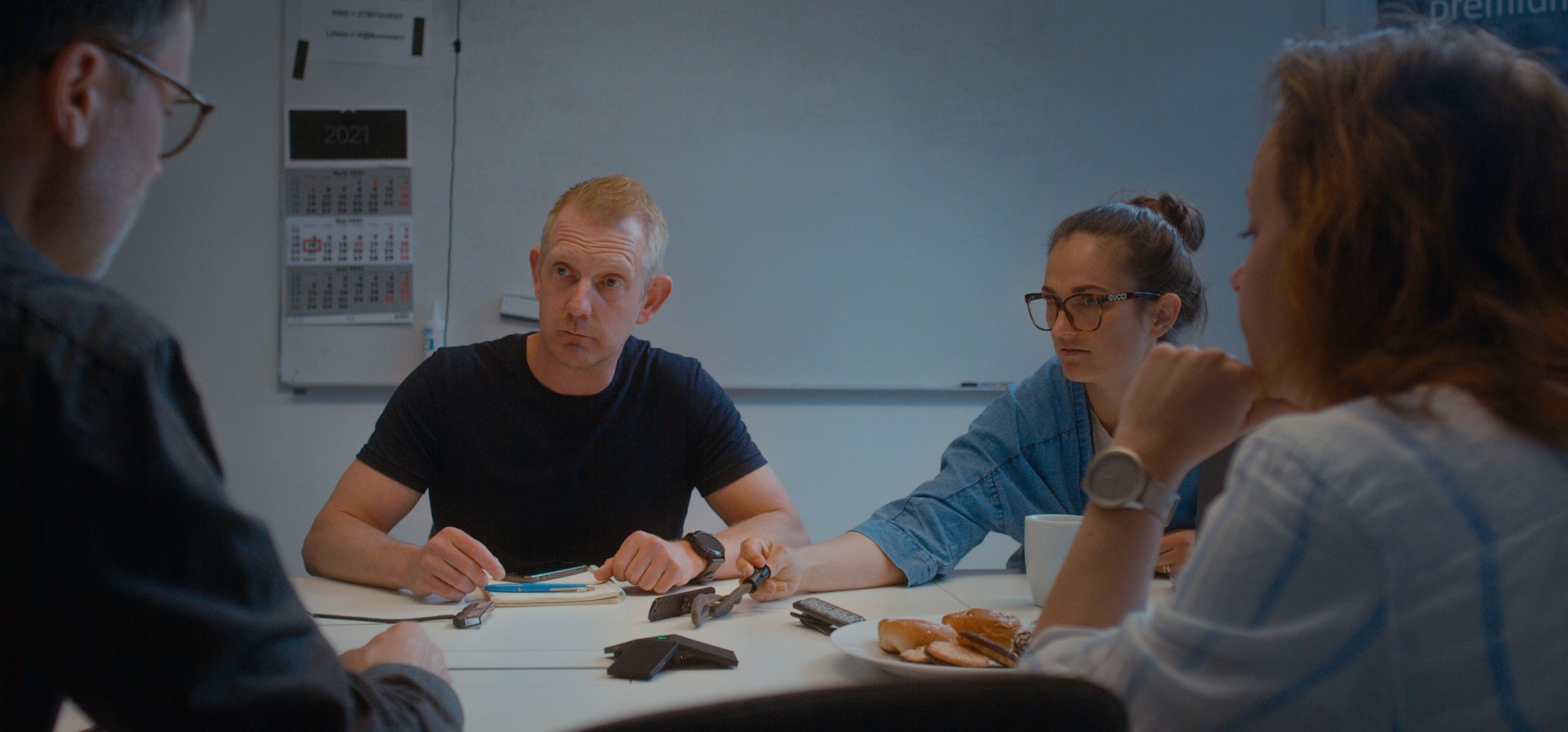 Fyra personer sitter i möte i ett konferensrum.